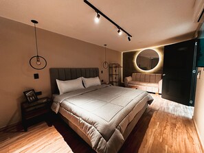 Ein modernes Schlafzimmer mit einem großen Bett, Nachttischen, einem runden Spiegel und einem Kleiderschrank.