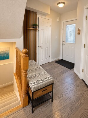 A staircase with a wooden handrail leading to a landing with a bench. - The Cozy Grove | Family 3+1BR & Spacious Backyard (Kitchener)