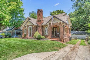 A two-story brick house with a front porch, a chimney, and a well-maintained lawn. - Downtown 3-bedroom HPU & Furniture Mkt (High Point)