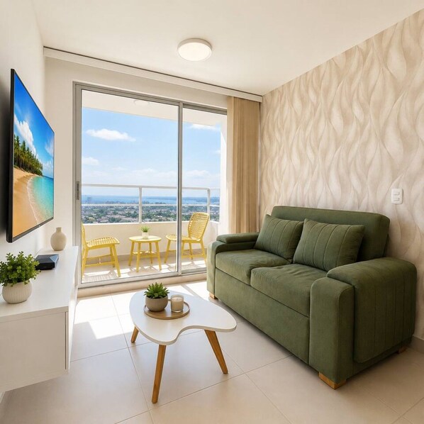 A modern living room with a green sofa, a white coffee table, and a balcony with yellow chairs. - Citrus Cove | Sea Views, Pool & 3BR (Cartagena)