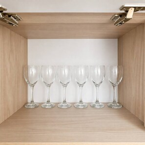 A wooden cabinet with a white interior, holding six clear wine glasses. - Citrus Cove | Sea Views, Pool & 3BR (Cartagena)