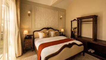 Habitación de hotel con una cama grande, lámparas de noche, un espejo y vistas al exterior.