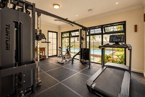 A home gym with a treadmill, exercise bike, and weight machine.