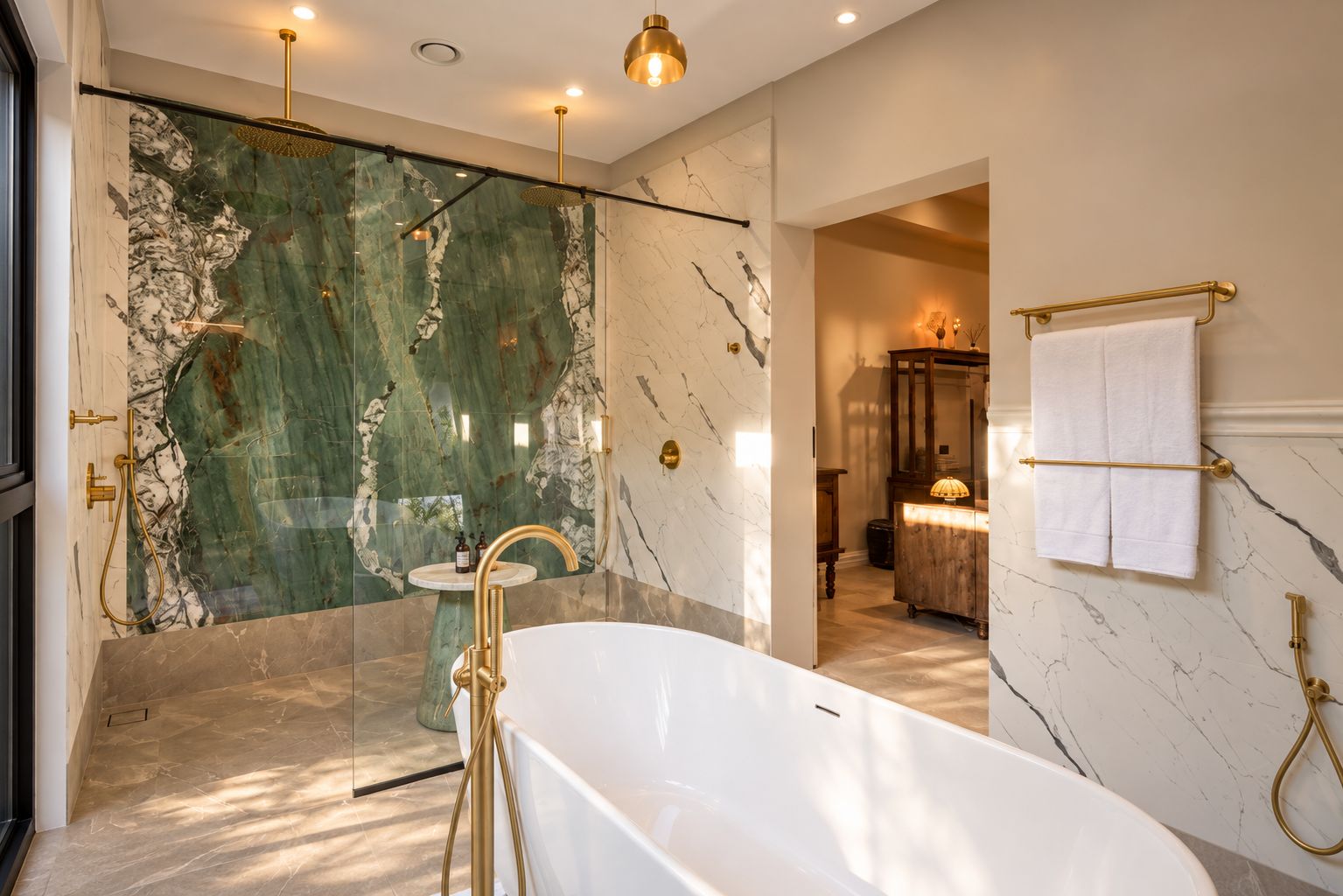 A modern bathroom with a freestanding bathtub, marble walls, and gold fixtures.