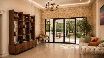Un salón espacioso con una amplia estantería de madera, un sofá cómodo y vistas a un área exterior a través de un ventanal.