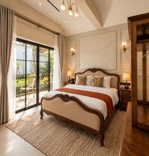 A spacious bedroom with a large bed, a wooden headboard, two bedside lamps, and a view of a garden through a sliding glass door.