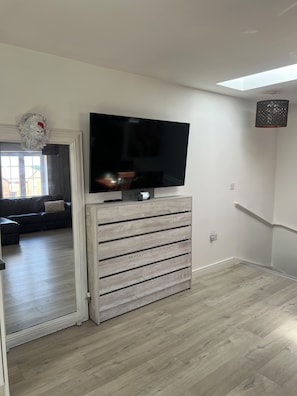 Un salon moderne avec un téléviseur à écran plat fixé à un meuble en bois, un canapé et une tête de lion décorative.