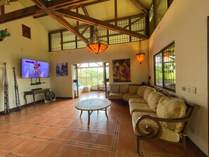 A spacious living room with a large sectional sofa, a television, and a dining area with a table and chairs. - 3BR Villa  Private Pool by Carara Park (lagunillas)