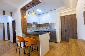 Eine moderne Küche mit Kochinsel, Barhocker und eingebautem Backofen.
