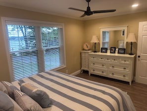 A bedroom with a bed, dresser, and ceiling fan.