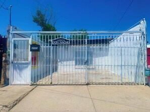 Une entrée fermée par un portail, sur laquelle on peut lire l’inscription « CASITA DON NACHO » et le numéro « 2955 » sur un bâtiment.