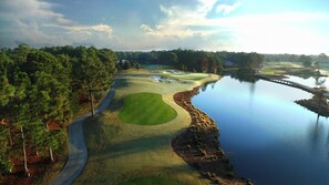 A golf course with a water body, trees, and a clear sky. - Sandestin Condo with Pool, Tram & Resort Perks (Miramar Beach)