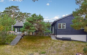 A two-story house with a wooden deck and a staircase leading to the entrance. - Stunning home in Borrby with house a panoramic view (Borrby)