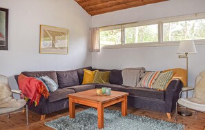 A cozy living room with a sectional sofa, a wooden coffee table, and a window with curtains. - Stunning home in Borrby with house a panoramic view (Borrby)