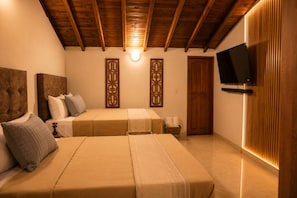 A bedroom with two beds, wooden headboards, a flat-screen TV, and a wall-mounted light fixture. - Reserva Monteverde Rio Negro (Rionegro)
