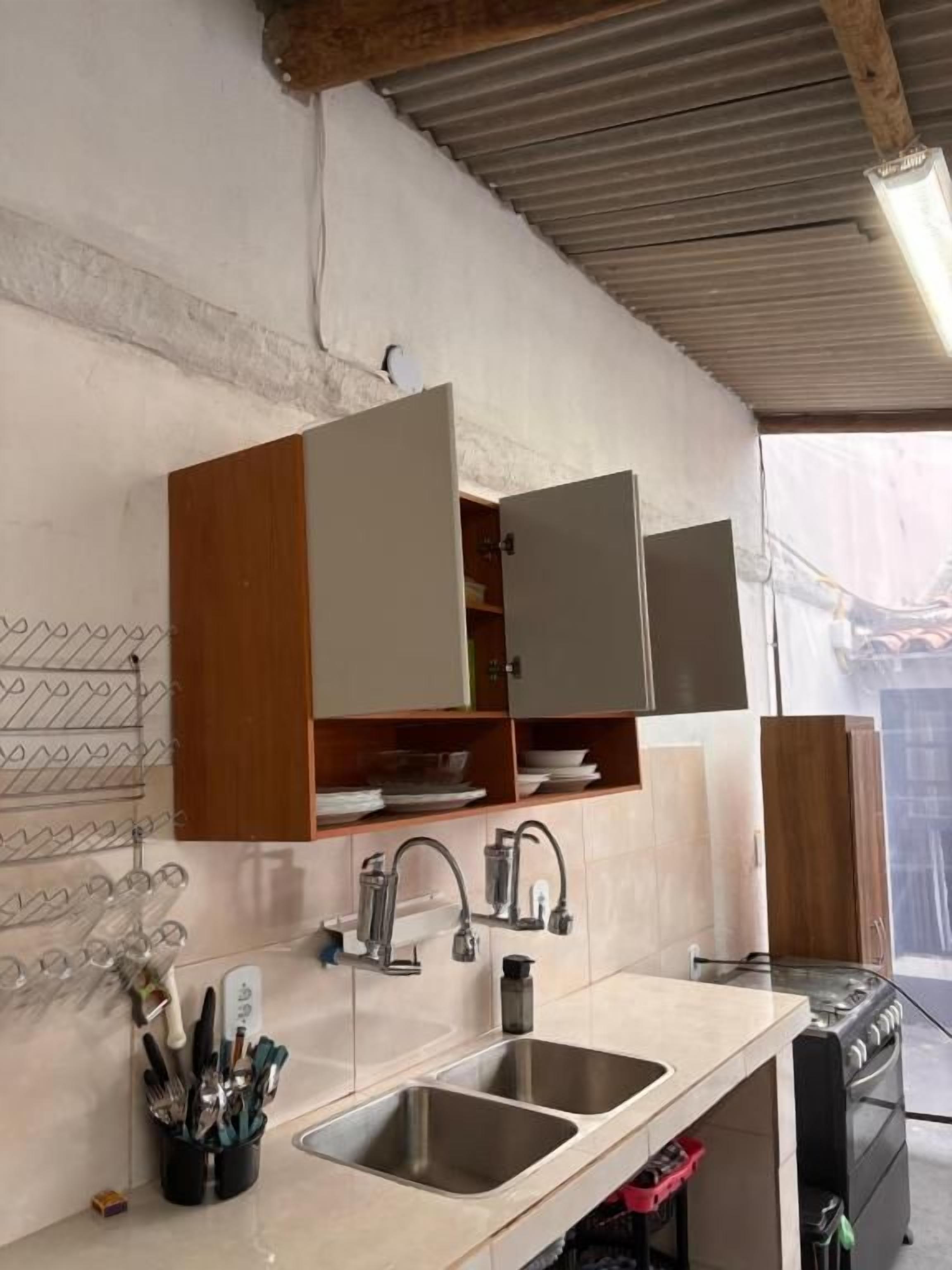 Una cocina con dos fregaderos, armarios de madera y una estufa.