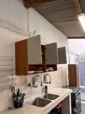 Una cocina con dos fregaderos, armarios de madera y una estufa.