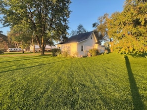 Ein Haus mit gepflegtem Rasen und einem großen Baum im Vordergrund.