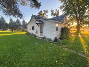 A small, single-story house with a sloped roof, a front door, and a small porch area.