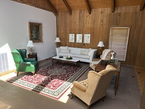 A furnished living room with a sofa, armchairs, a coffee table, and a patterned rug. - Massive 7-bedroom House in Charming Hayden (Hayden)
