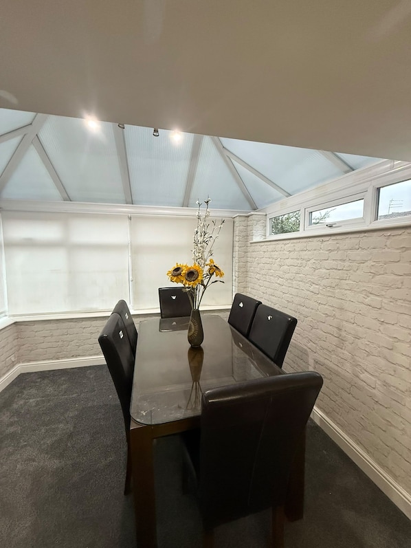 A conference room with a glass ceiling, a wooden table, and black chairs.