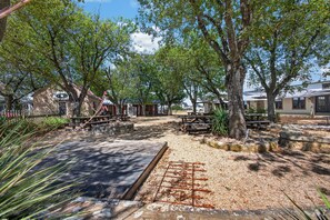 A park with picnic tables, a playground, and a building with a star sign. - Cabin w/King bed on Wine Trail, Walk to Wineries! (Fredericksburg)