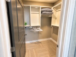 Ein begehbarer Kleiderschrank mit Kleiderstange und Ablagefläche.