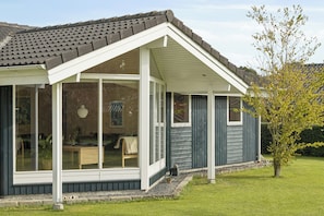 A conservatory with a glass roof, wooden flooring, and a view of the garden. - Cosy, modern holiday home in a lovely area (Juelsminde)