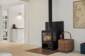 Ein modernes Interieur mit Kaminofen, Korbwäsche und einer Karte an der Wand.