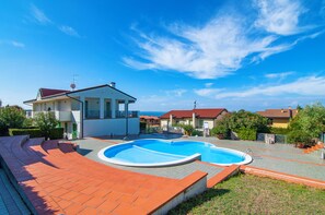 A residential area with a swimming pool, houses with red-tiled roofs, and a clear blue sky. - Kedimore - GoldenHouse Lazise (Lazise)