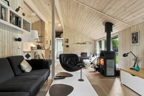 A cozy living room with a fireplace, a sofa, a chair, and a bookshelf. - Lovely house on Helgenæs (Knebel)