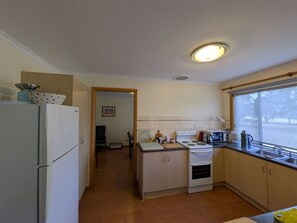 A compact kitchen with a refrigerator, stove, and sink.