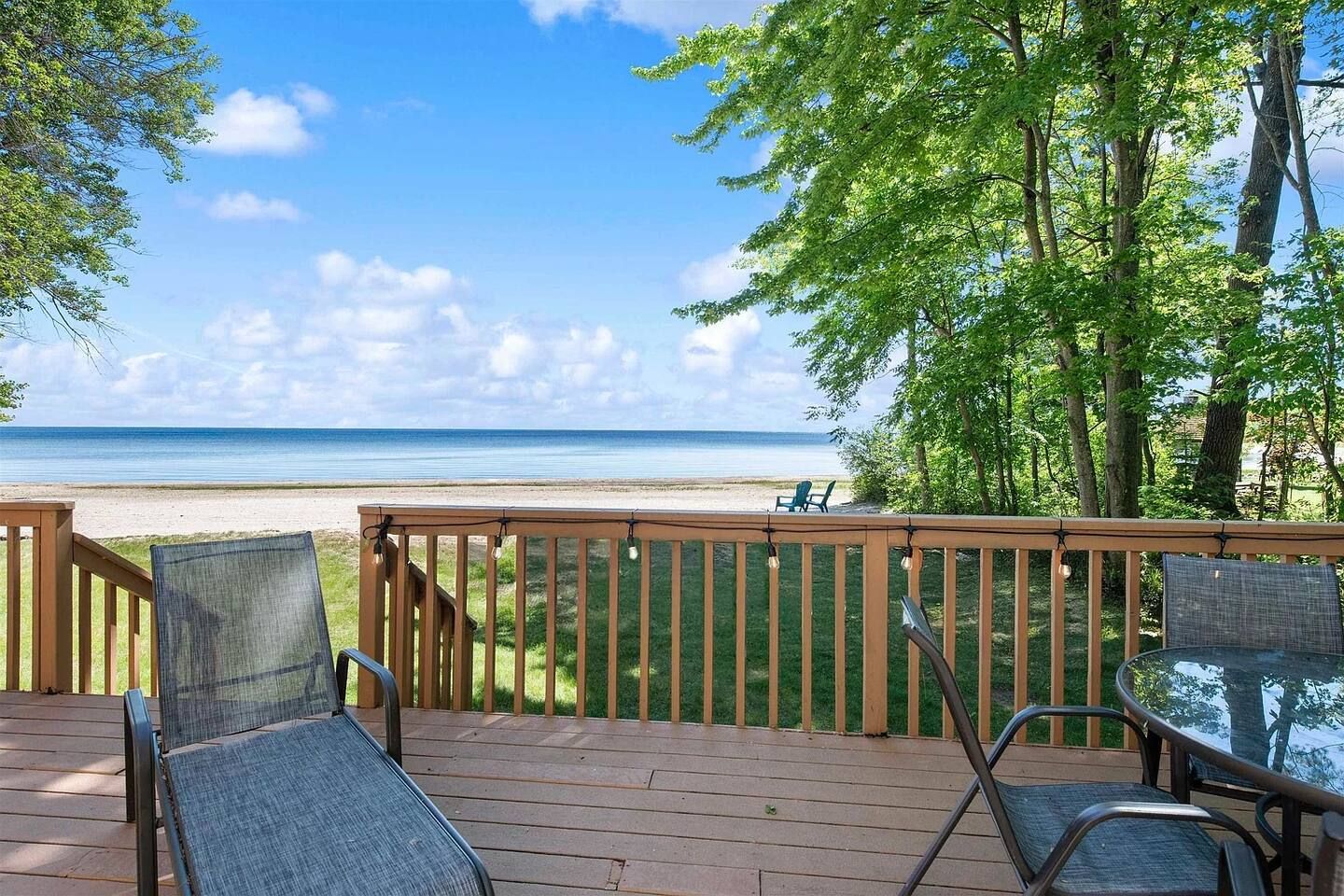 A deck with outdoor seating overlooking a beach.