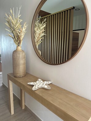 Een houten console tafel met een gevlochten vaas en een zeester decoratie.