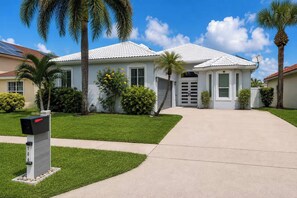 A two-story house with a white exterior, a driveway, and a mailbox. - Lakefront Pool Home near Wellington Polo & Beaches (West Palm Beach)