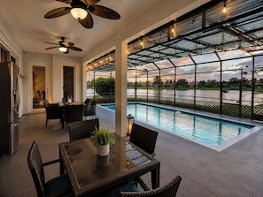 A covered outdoor area with a pool, seating, and a ceiling fan. - Lakefront Pool Home near Wellington Polo & Beaches (West Palm Beach)