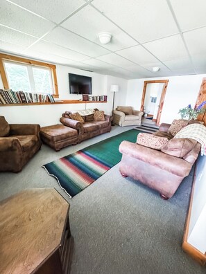 A living room with a sofa set, a television, and a bookshelf. - Enjoyable 4-bedroom house in Derby perfect for your getaway (Derby)