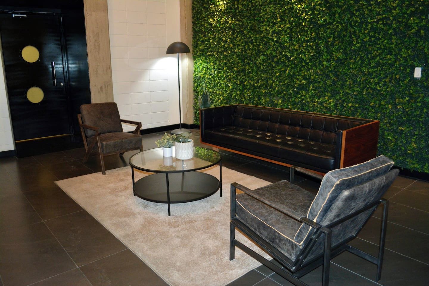Un salon moderne avec un canapé, un fauteuil et une table basse.