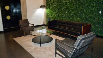 Un salon moderne avec un canapé, un fauteuil et une table basse.