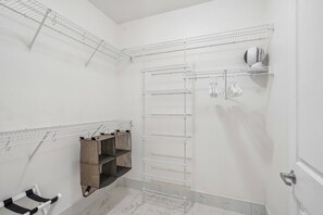 Casa de banho com chuveiro, porta-toalhas e um espaço para secar roupa.