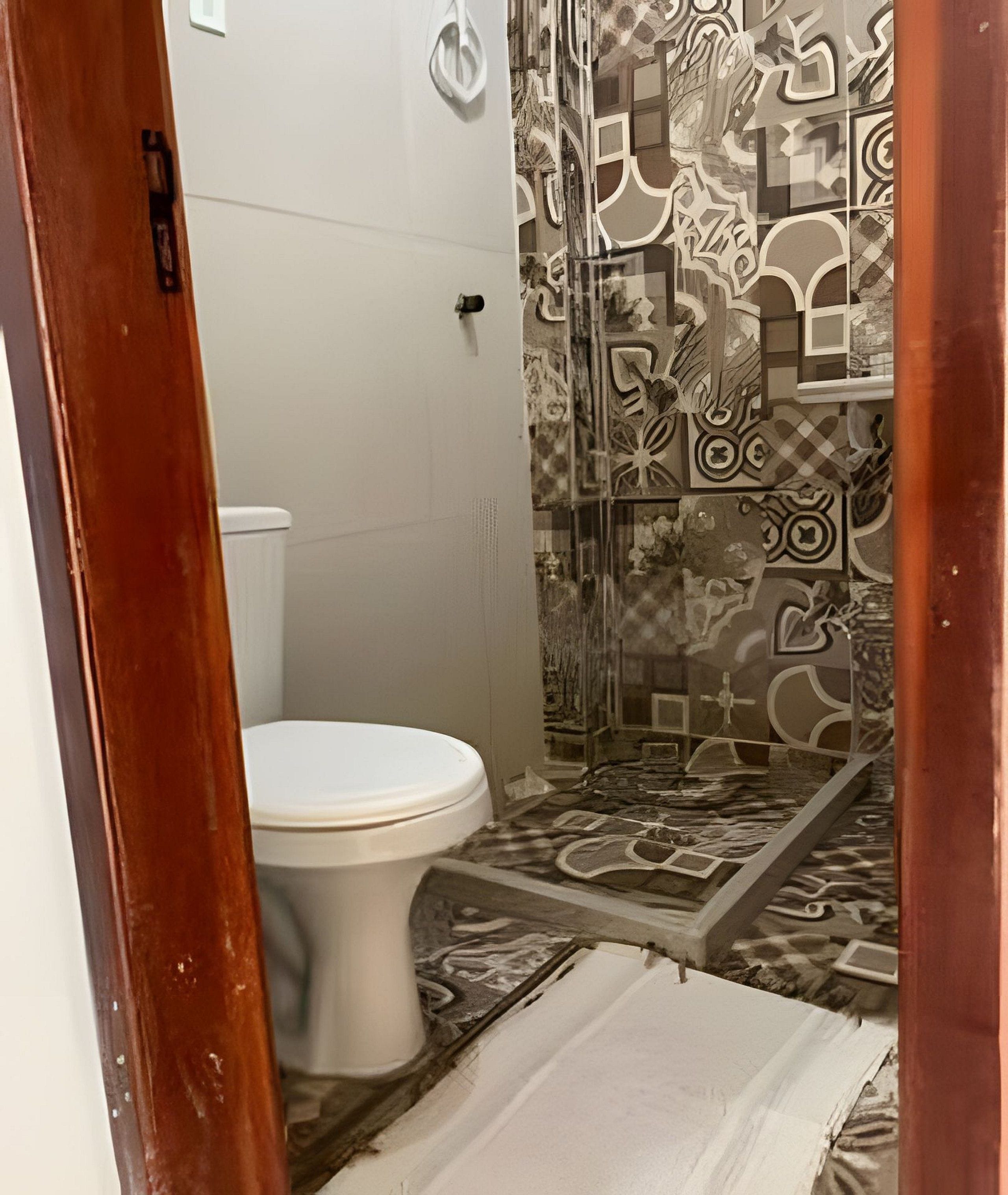 Une salle de bain avec des toilettes, une douche et des carreaux de sol à motifs.