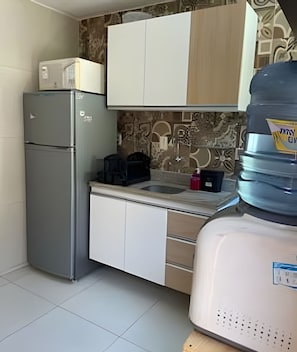 A compact kitchen with a refrigerator, a water dispenser, and a coffee maker. - Porto de Galinhas Maraca 70m Mar Loctemp (Ipojuca)