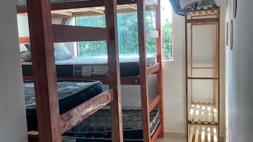 Ein Schlafsaalzimmer mit Stockbetten, einem Fenster und einer Klimaanlage.