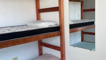 A bunk bed with a mirror on the wall.