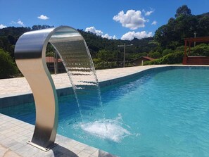 A swimming pool with a modern water feature. - Pousada Thermas das Montanhas (Aguas de Lindoia)