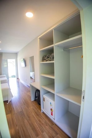 A room with a large walk-in closet, wooden flooring, and a window providing natural light. - Pousada Thermas das Montanhas (Aguas de Lindoia)