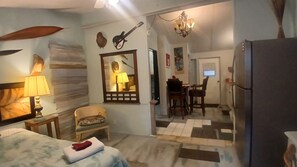 A hotel room with a bed, a chair, a desk, and a dining area. - Charming Efficiency unit in enjoyable Ormond Beach House with Tropical Garden (Ormond Beach)