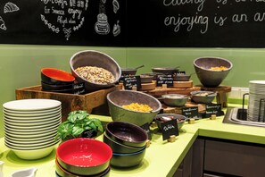 Disposição de buffet com diversas tigelas de comida e pratos.