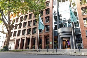 En moderne bygning med facade i mursten, store vinduer og en buet indgang.