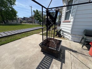 Eine Terrassenfläche mit Grill aus Metall und Betonboden.